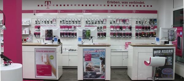 Telekom Shop mit moderner Ladeneinrichtung, Smartphones und Zubehör an der Wand.
